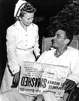 Photo # 80-G-17678:  Ensign George H. Gay with a nurse and a newspaper featuring accounts of the Battle of Midway.  Gay was the only survivor of Torpedo Squadron Eight's 4 June 1942 attack on the Japanese aircraft carrier force.