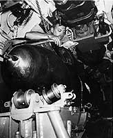 Photo # 80-G-49457:  Sailor reads in his bunk, atop a torpedo on board USS Bullhead, 1945
