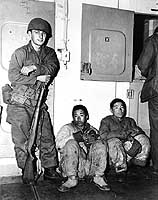 Photo # NH 103229: Marine guards POWs on board USS General J. C. Breckinridge circa late December 1950.