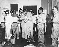 Photo # NH 69416:  LCdrs. Hibbs and Gates make merry with toy musical instruments, 24 December 1944