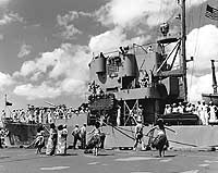 Photo # NH 73685: Hula dancers welcome USS Incredible to Hawaii, while she was en route to the U.S. from Korea, 1951