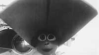 Photo # NH 99576:  Torpedo warhead decorated with a painted face, in one of USS Hovey's torpedo tubes during the 1930s