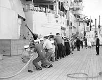 Photo # NH 103679: Crew members hauling up a life boat on board HMS Vanguard, 12 September 1952.  Photographed by Blanchette