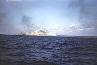 Photo # NH 104355-KN: Battleship (probably USS Tennessee) bombarding Iwo Jima, circa 19 February 1945. Original Kodachrome 35mm color slide taken by Lt. Howard W. Whalen, USNR.