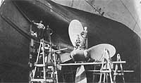 Photo # NH 106337:  Men pose on USS Powhatan's starboard propeller and rudder, while she was in dry dock at Newport News, Virginia, 1919