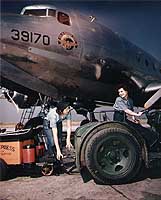 Photo # 80-G-K-5659: Seamen Billy Ikard and Barbara
A. Patterson move a battery cart next to a transport plane, circa mid-1945